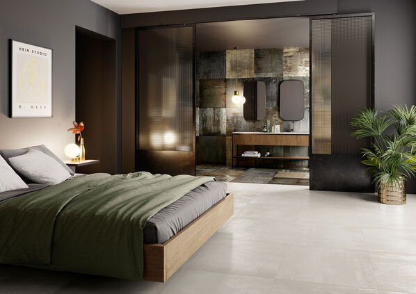 Schlafzimmer mit angrenzendem Badezimmer. Beide Räume sind mit Fliesen in Metalloptik ausgestattet - Ceramicvision Blade 
