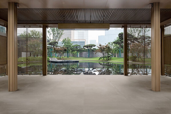 Japanisch anmutender überdachter Terrassenbereich mit angrenzendem Garten. Die weitläufige Bodenfläche ist mit der Imola Ceramica Azuma Outdoor gefliest.