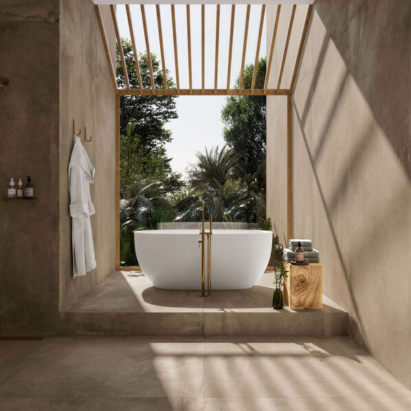 Großzügiges Badezimmer im mediterranen Flair: Der Blick fällt auf eine vor Kopf aufgestellte weiße Badewanne. Wände und Böden sind mit der Imola Ceramica Azuma Up Fliese gestaltet, die ein warmes mediterranes Flair bewirken.