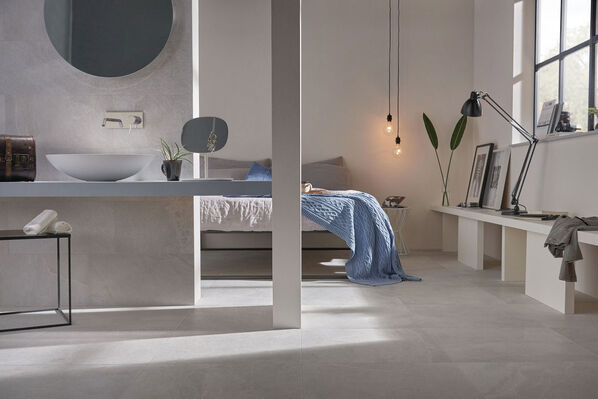 Schlafzimmer mit angrenzendem offenen Badezimmer, welche auf dem Boden mit der Imola Ceramica X Rock in der Farbe White gestaltet wurden.