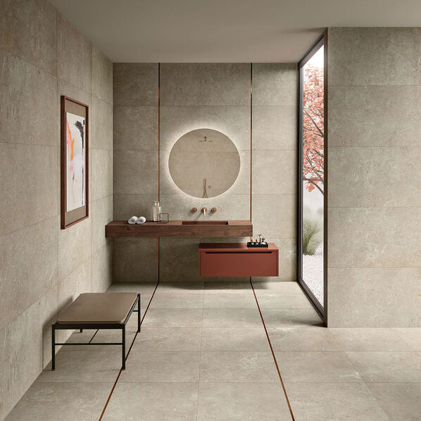 Minimalistisch eingerichtetes Badezimmer mit einem vor Kopf stehenden Waschtisch. Die Fliesen des Badezimmers sind aus der Serie Pure Stone des Fliesenherstellers Magres. 