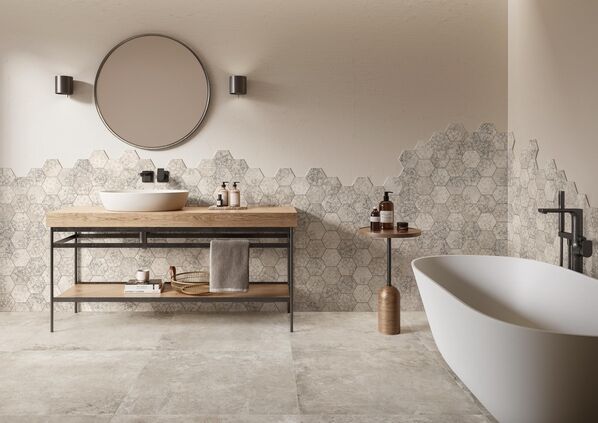 Badezimmer in hellen Sandtönen. Die Wand mit sechseckigen Dekorfliesen in eleganter Betonoptik bildet das Highlight des Badezimmers.