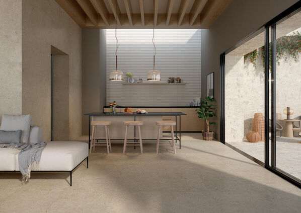 Wohn- und Esszimmer mit angrenzender Terrasse im mediterranen Stil. Fußboden und Wände sind mit sandfarbenen Steinfliesen (Marazzi Caracter) gestaltet. 