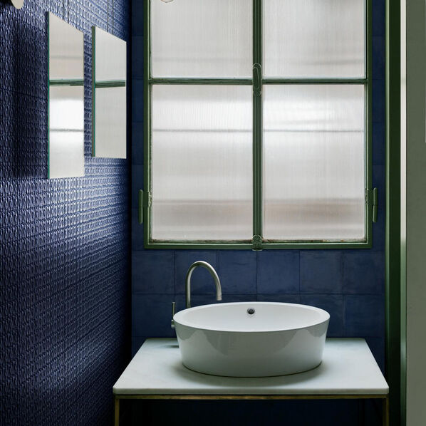 Blau gefliestes Badezimmer mit großem Fenster und Waschbecken vor Kopf. Die blauen Wandfliesen sind aus der Marazzi Memoria Kollektion.