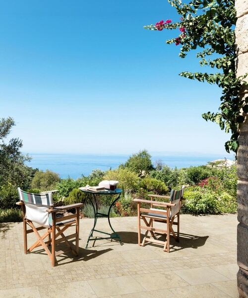 Terrasse mit Tisch und zwei Stühlen. Der Natursteinboden (Marazzi Uniche20) erschafft ein mediterranes Flair.