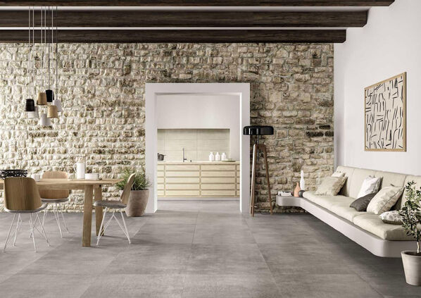 Wohnzimmer mit grauem Fliesenboden in Betonoptik (Marazzi Memento).