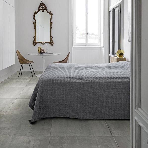 Schlafzimmer mit grauem Fliesenboden in Betonoptik (Marazzi Mineral, in der Farbe Iron.)