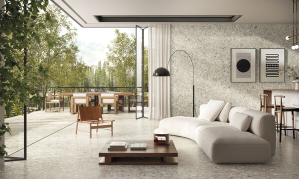Wohnzimmer mit angrenzendem Balkon, das mit Fliesen im Terrazzo-Stil gestaltet ist /ceramicvision Reaction).