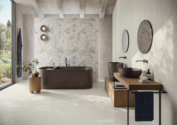 Badezimmer in hellen Sandfarben und kunstvollem Wanddekor hinter einer freistehenden Badewanne. Die Wand- und Bodenverkleidung wurde mit der ceramicvision Mockup realisiert.