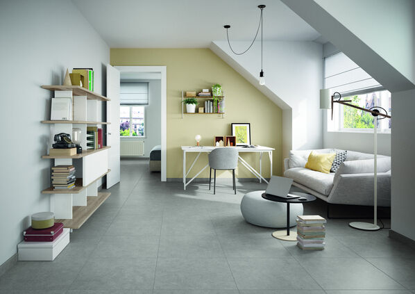 Gemütlicher Wohnraum mit einem grauen Fliesenboden (Villeroy & Boch Back Home) und weißen und gelben Wänden. 