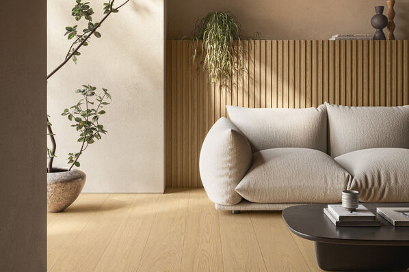 Wohnzimmer mit Couch und elegantem Fliesenboden in Holzoptik - Ceramiche Caesar Pure.