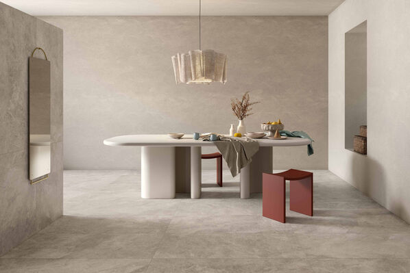 Esszimmer mit Tisch und darüber hängendem Lampenschirm. Boden und Wände sind mit Fliesen in warmer Steinoptik gestaltet - Ceramiche Caesar Haven.